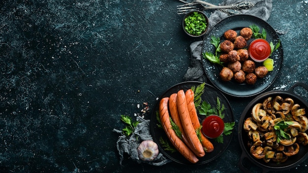 Set of dishes of meat and vegetables on black background Top view Free space for your text