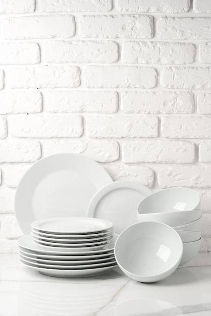 Set of dishes on table against brick wall background