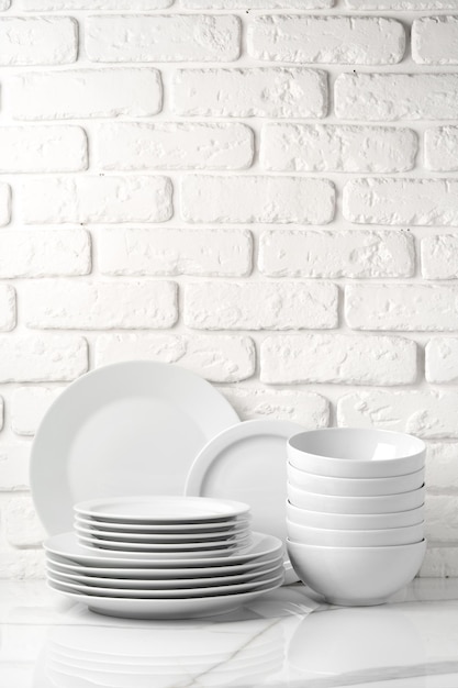 Set of dishes on table against brick wall background