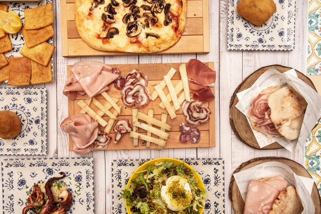 Foto set di piatti della cucina tipica italiana con centro in legno con antipasto