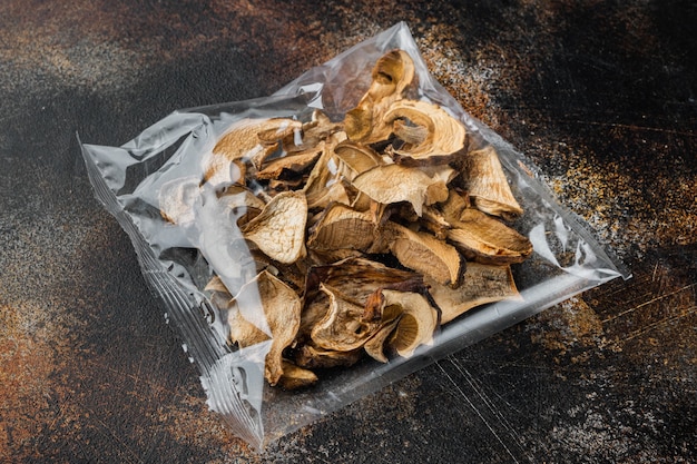 Set of dried mushrooms set, on old dark rustic, in plastic pack