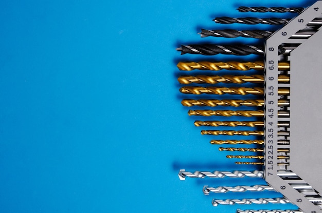 Set of drills for wood, metal and concrete on a blue background.