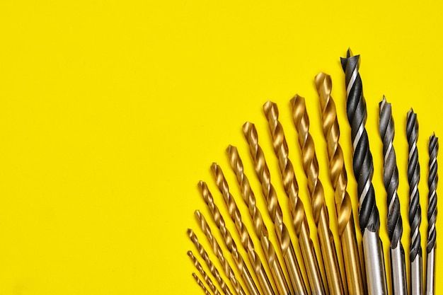 Set of drills for wood and metal on a yellow background.