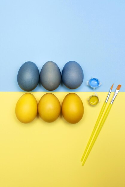 Set of Easter eggs paints and brush on a background of the Ukrainian flag for children for peace