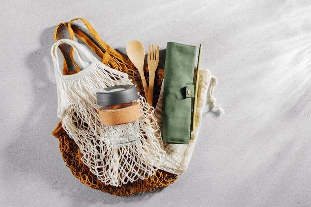 Set of Eco friendly bamboo cutlery, eco bag and reusable coffee mug. Sustainable lifestyle. Plastic free concept.