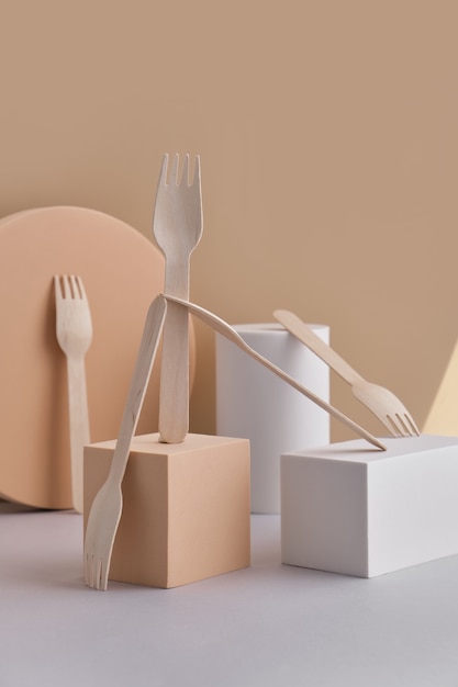 Set of eco-friendly tableware, wooden forks placed on trendy podiums and geometric pedestals