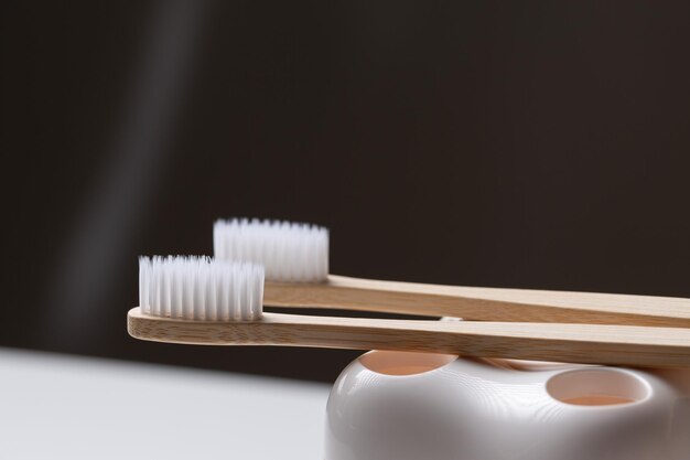 A set of ecofriendly bamboo wooden toothbrushes in a toothshaped holder