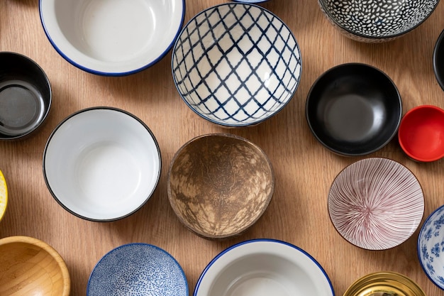 Set of empty bowls of different textures and colors on oak background