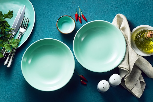 Set of empty plates on a blue table.