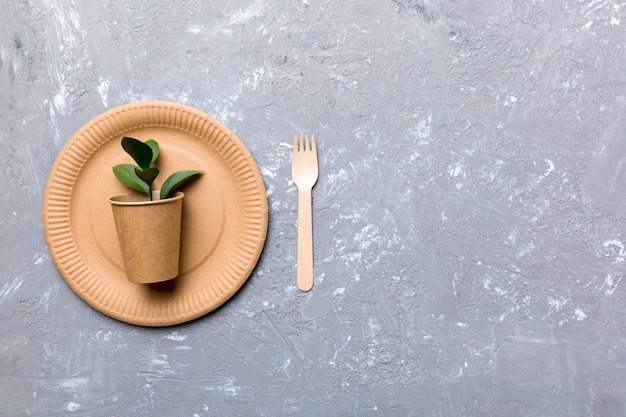 Set of empty reusable disposable eco-friendly plates, cups, utensils on light white colored table background. top view. Biodegradable craft dishes. Recycling concept. Close-up