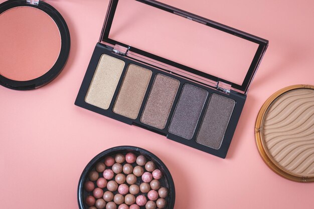 A set of female cosmetics on a pink background