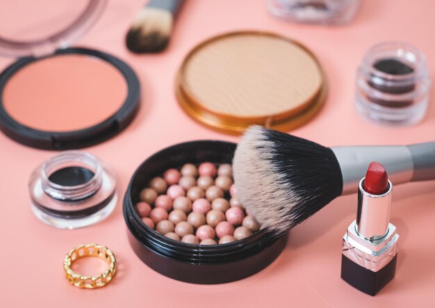 A set of female cosmetics on a pink background