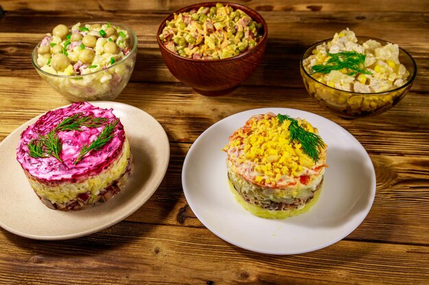 Set of festive mayonnaise salads on wooden table