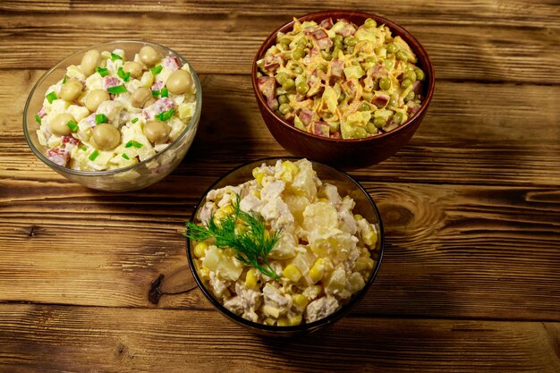 Set of festive mayonnaise salads on wooden table