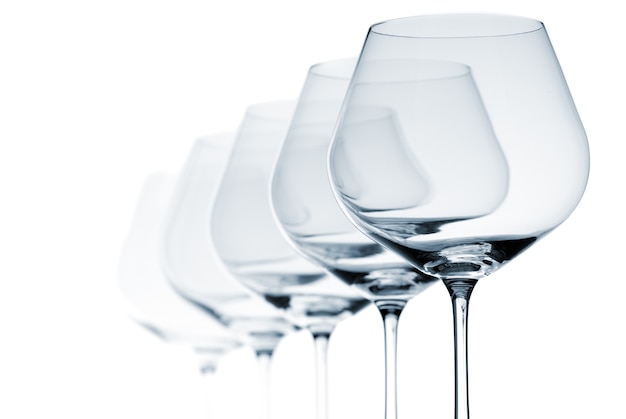 Set of five empty wine glasses on white background