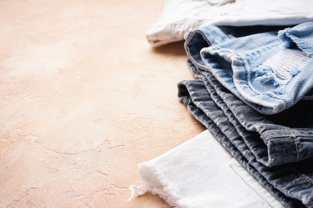 Set of folded jeans on a beige  , space for text. Close-up