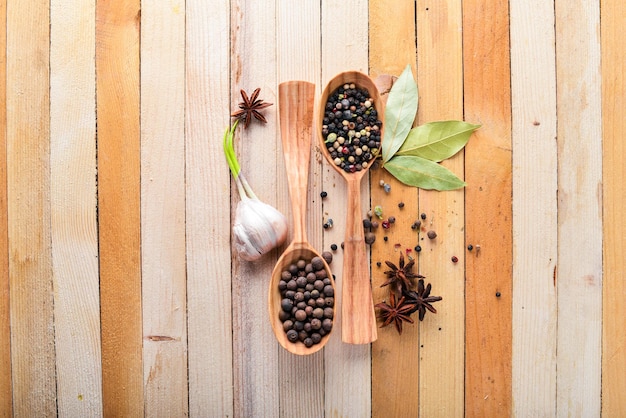 A set of fragrant spices A mixture of black and red pepper coriander paprika On Wooden background Top view Free space