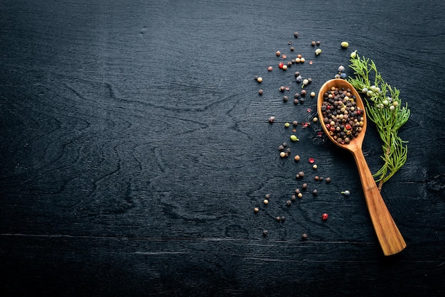 A set of fragrant spices A mixture of black and red pepper coriander paprika On Wooden background Top view Free space