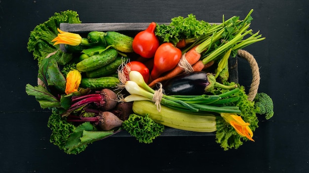 A set of fresh vegetables in a wooden box On a wooden background Top view Copy space