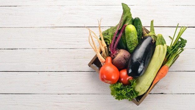 A set of fresh vegetables in a wooden box On a wooden background Top view Copy space