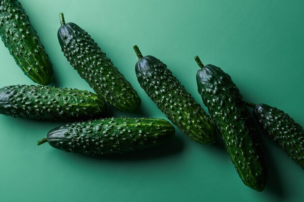 Set of fresh whole cucumbers on a green background, food\
pattern. garden cucumber wallpaper backdrop design
