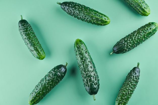 Set of fresh whole cucumbers on a green background, food\
pattern. garden cucumber wallpaper backdrop design