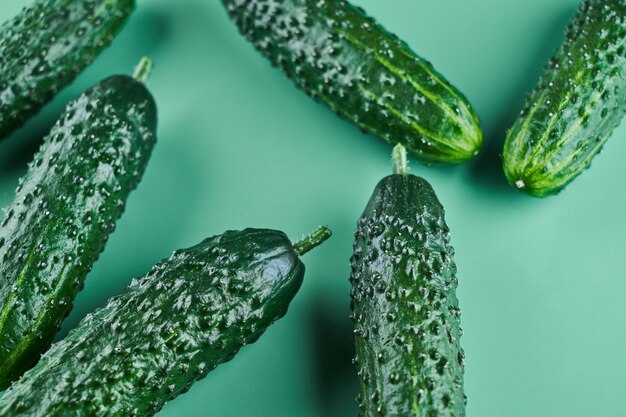 Set of fresh whole cucumbers on a green background, food pattern. Garden cucumber wallpaper backdrop design