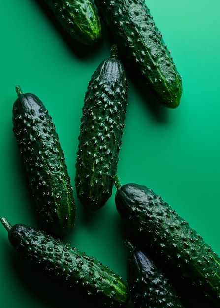 Set of fresh whole cucumbers isolated on green.