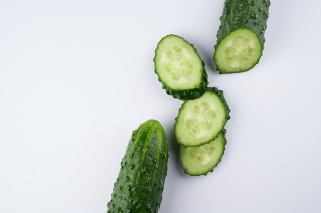 Set of fresh whole and sliced cucumbers on white background. Garden cucumber green wallpaper backdrop design