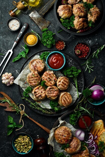 Un set di cotolette di carne fritte e ricetta fatta a mano di shish kebab su uno sfondo di pietra nera vista dall'alto