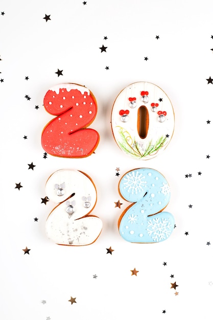 Photo set of gingerbread biscuits in shape of numbers of new year on white background