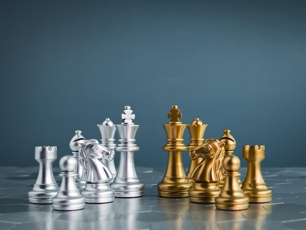 Set of golden and silver chess pieces element king queen rook bishop knight pawn standing on hexagon pattern chessboard on blue background Competition game war emulation and planning concept