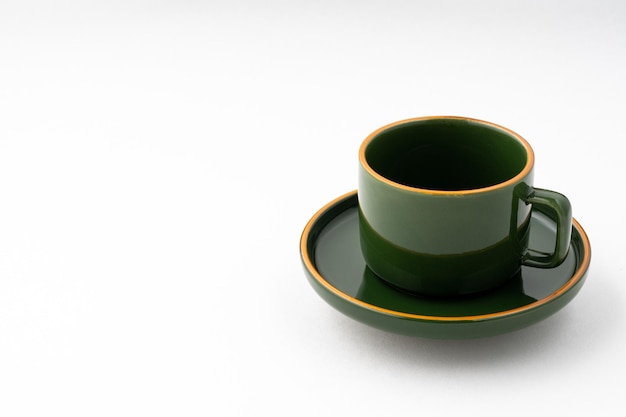 Набор зеленой керамической тарелки и кофейной кружки на белом фоне