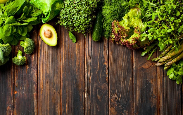 Set of green vegetables and greens on a wooden background. Mono color food diet for detoxification