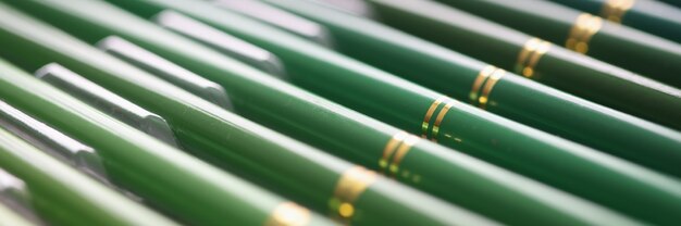 Set of green wooden pencils in different shades closeup