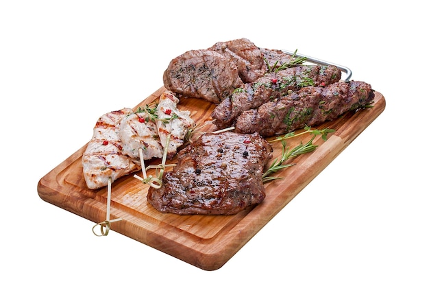 Set of grilled meat on a wooden Board Chicken fillet beef steak pork medallion lamb kebab On a white background