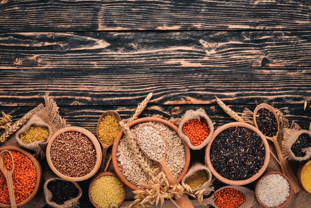 Set of Groats and Grains Buckwheat lentils rice millet barley corn black rice On a wooden  background Top view Copy space