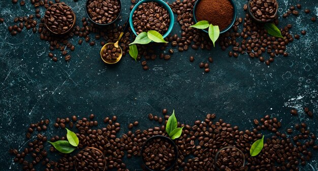 挽いたコーヒーと黒い石の背景にコーヒー豆のセット上面図テキストの空き領域