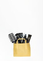 Photo a set of hairdressing combs and scissors in black color in a craft package on a white background