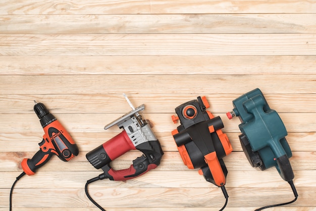 Photo set of hand carpentry power tools for woodworking lies on a light wooden background. directly above