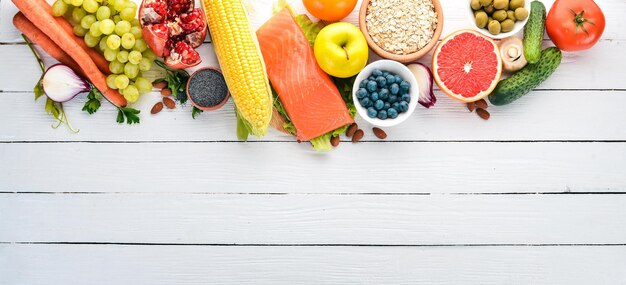 A set of healthy food. fish, nuts, protein, berries, vegetables and fruits. on a white background. top view. free space for text