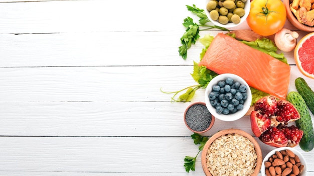 A set of healthy food Fish nuts protein berries vegetables and fruits On a white background Top view Free space for text