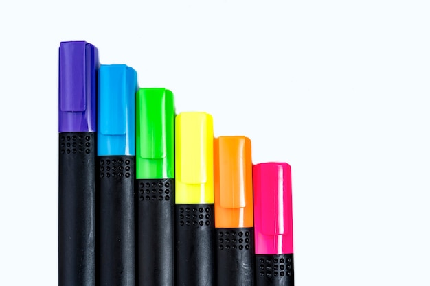 Set of highlighter markers sorted by color aligned in ladder on white background. Foreground.