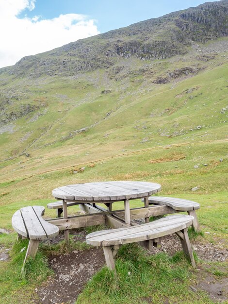 Set houten tafel en zitbanken in hebzuchtgrasveld buiten op de berg