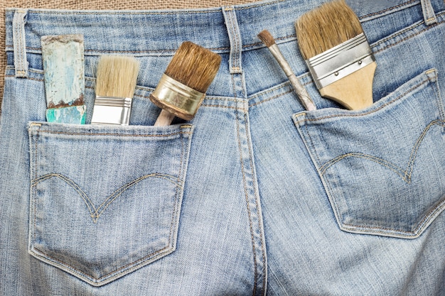 Set huisgereedschap voor reparatiewerkzaamheden in jeanszakken.