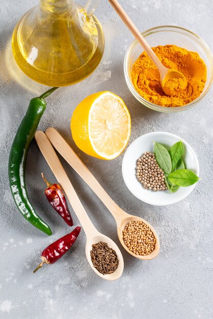 Set of Indian food cooking ingredients Traditional Indian assorted spices and herbs Curry cardamom garlic pepper curry leaves oil chili peppers lemon Preparing exotic meal Top view