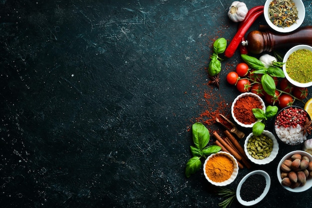 Set of Indian fragrant spices and herbs on a black stone background Top view Free space for text
