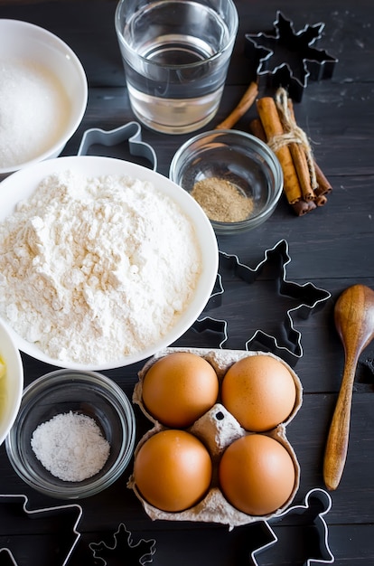 Foto set ingrediënten voor het koken van feestelijke peperkoek kerstkoekjes - boter, bloem, suiker, eieren, kruiden met suikerdecor, suikerglazuur, formulieren voor koekjes,