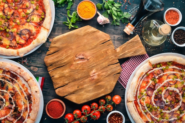 Foto un set di pizza italiana cucina italiana su sfondo di legno nero spazio per la copia gratuito vista dall'alto