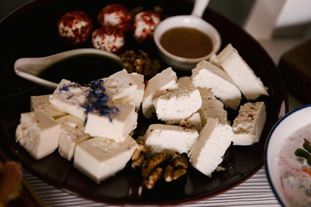 Набор итальянских закусок для фуршета Разнообразие сыров, колбасных изделий, брускетты, маринованных огурцов, помидоров на деревянном фоне